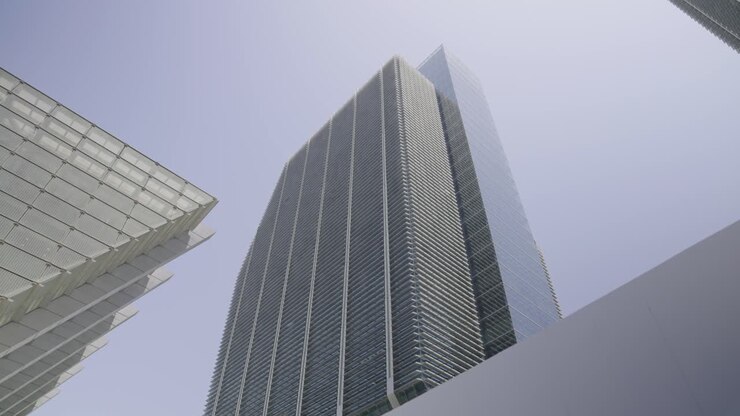 Immagine cinematografica statica diurna di un edificio dell'ADGM, ideale per contenuti visivi aziendali, finanziari e di città moderne