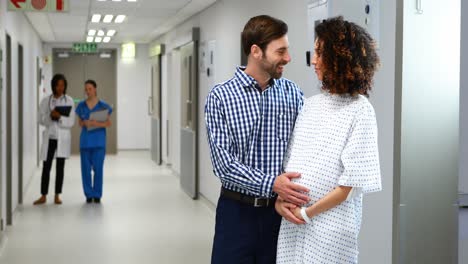 Man-interacting-with-pregnant-woman-in-corridor