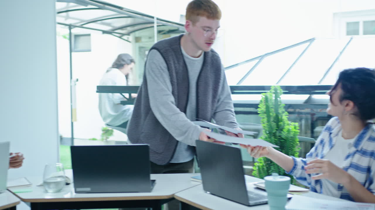 Young Man Explaining Financial Report to Business Team on Meeting