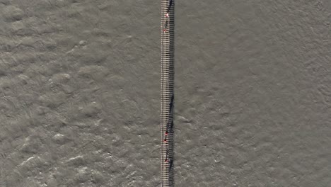 top down aerial view above hussaini suspension bridge, hunza river, pakistan. people crossing dangerous bridge near passu cones mountains