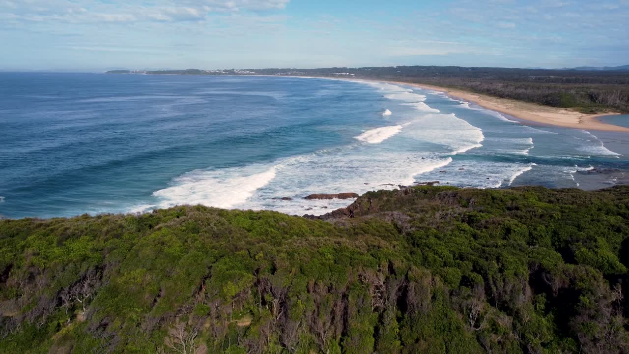 Drone aerial pan landscape shot of National Park bushland scenery view Pacific Ocean waves on sandy beach Old Bar Point travel tourism Taree Saltwater NSW Australia 4K