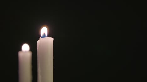 dos velas blancas encendidas y corriendo con algo de viento