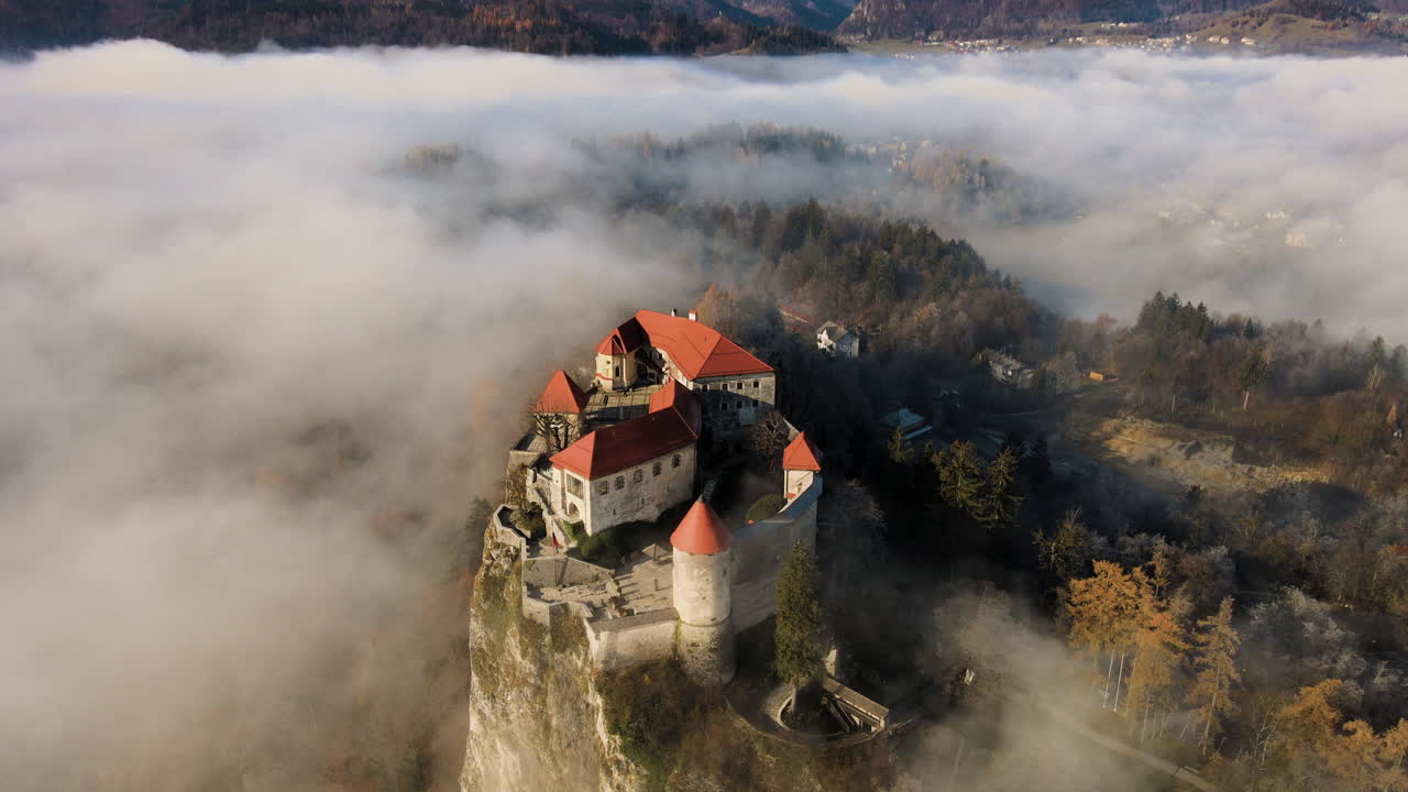 Maestoso Castello di Bled circondato da nebbia bassa, ora d'oro, Slovenia