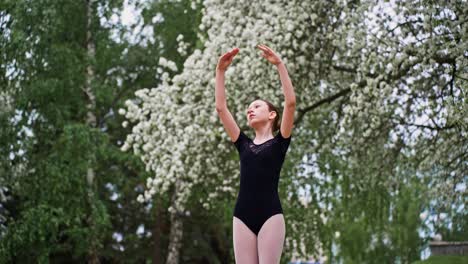 young ballerina practicing in a park