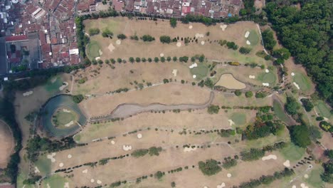 Huge-golf-course-in-city-of-Magelang,-Indonesia,-aerial-drone-view