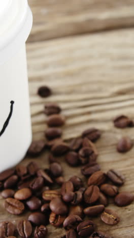cara sonriente en una taza desechable con granos de café en el saco