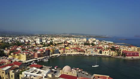 dramatic drone footage of chania, crete elevating above red rooftops to show its landscape