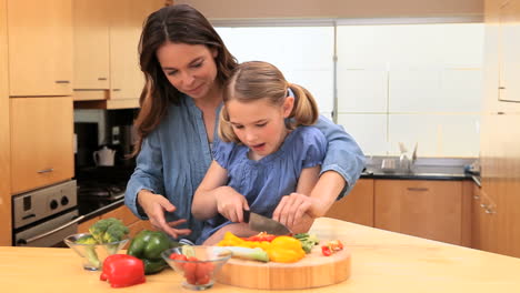 madre sonriente cocinando con su hija