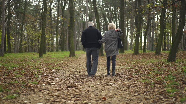 Senior couple walking in the forest during autumn