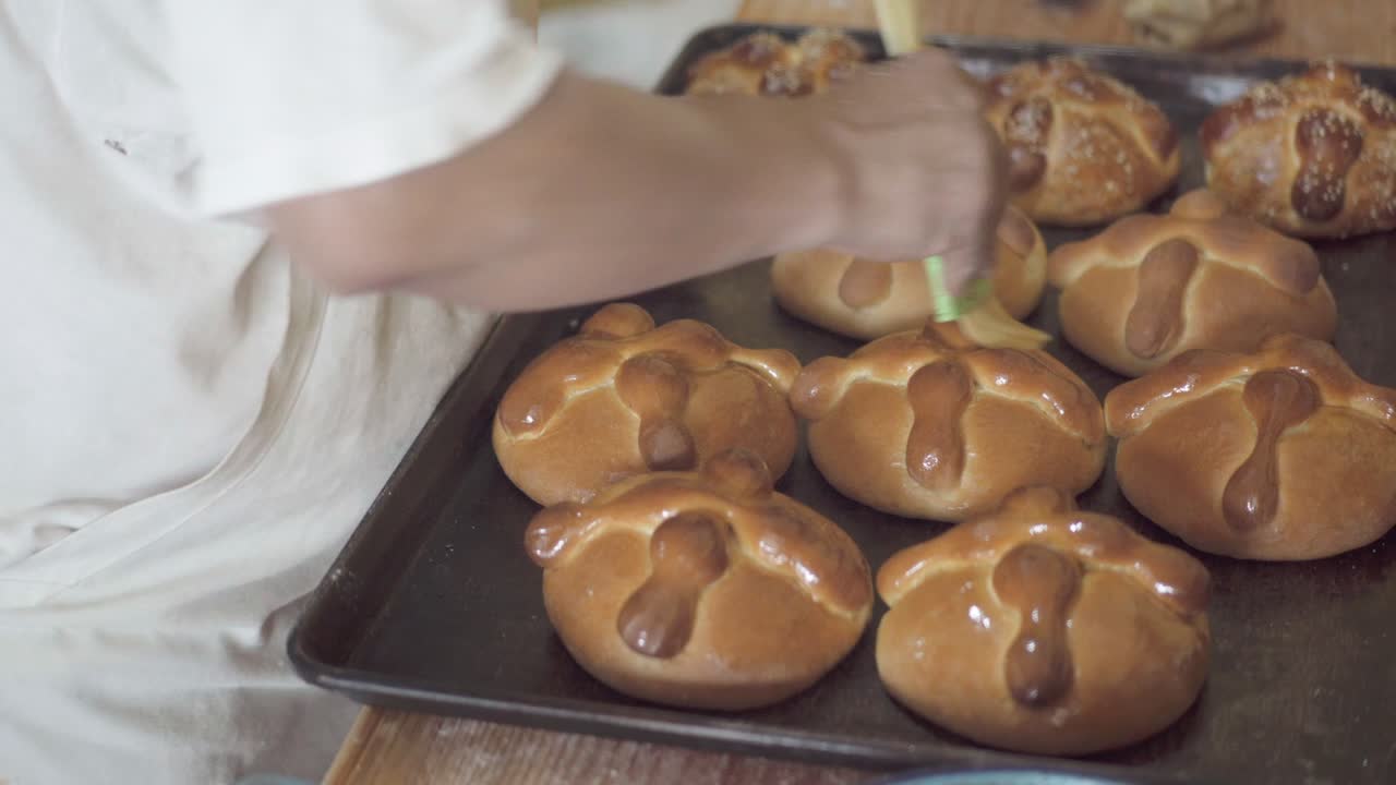 A pastry chef uses a brush to moisten dough with water or egg wash.