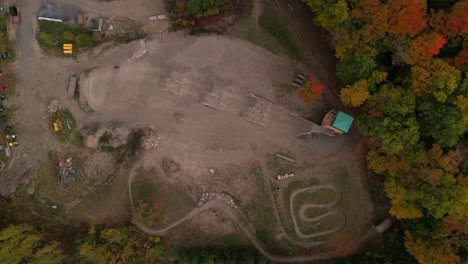 Vista-De-Pájaro-Del-Parque-De-Bicicletas-Mtb-Arriba-Mientras-El-Ciclista-Atraviesa-Los-Colores-Del-Otoño