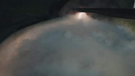 una densa niebla o humo que flota sobre un lago oscuro y tranquilo por la noche, creando un ambiente misterioso