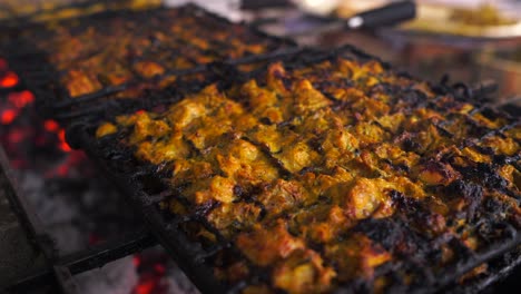 Chicken-satay-is-grilled-over-an-open-fire-with-hot-coals-and-smoke-coming-out-,-footage,-4k-footage