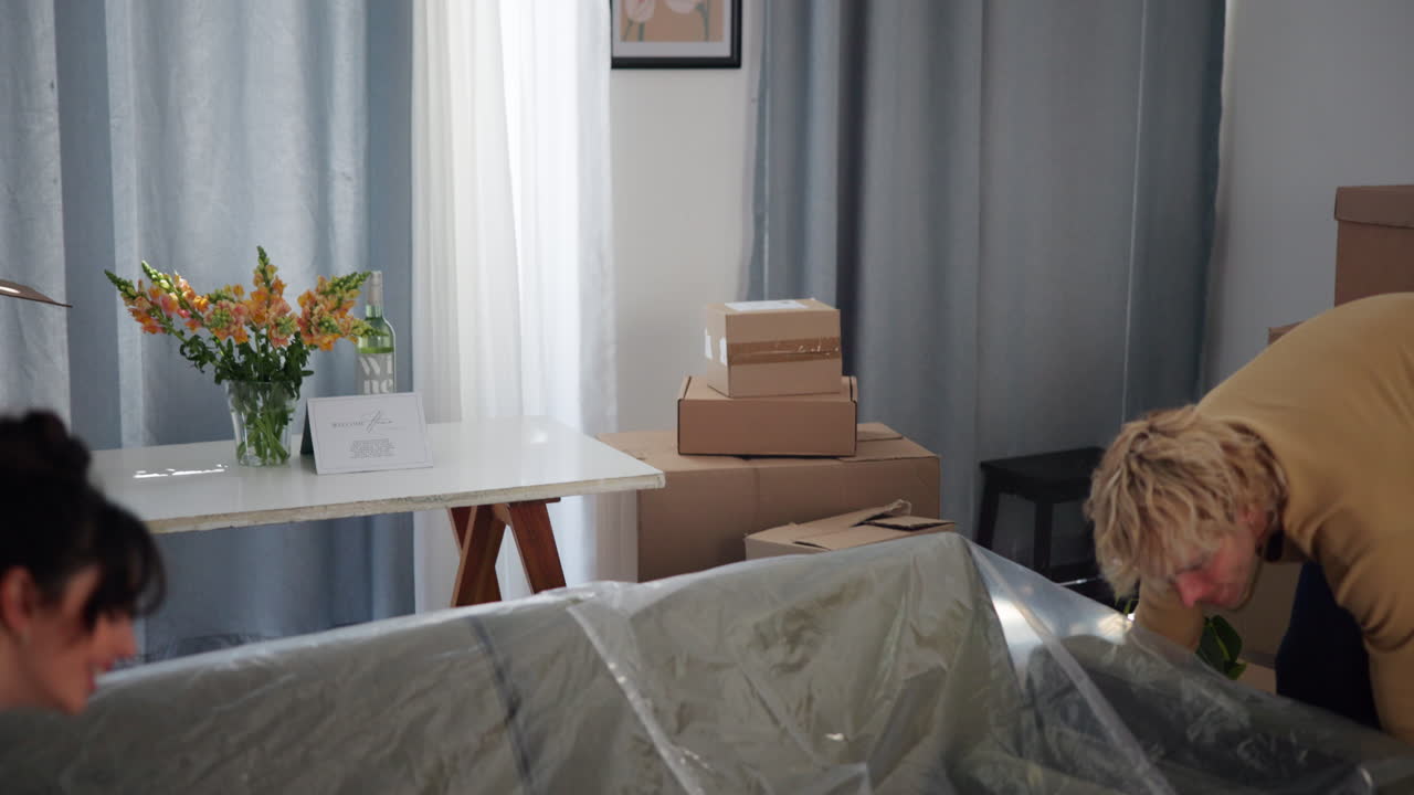Happy Young Couple Relaxes on New Couch After Moving into Apartment