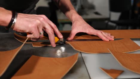 leather craftsman cutting leather pieces