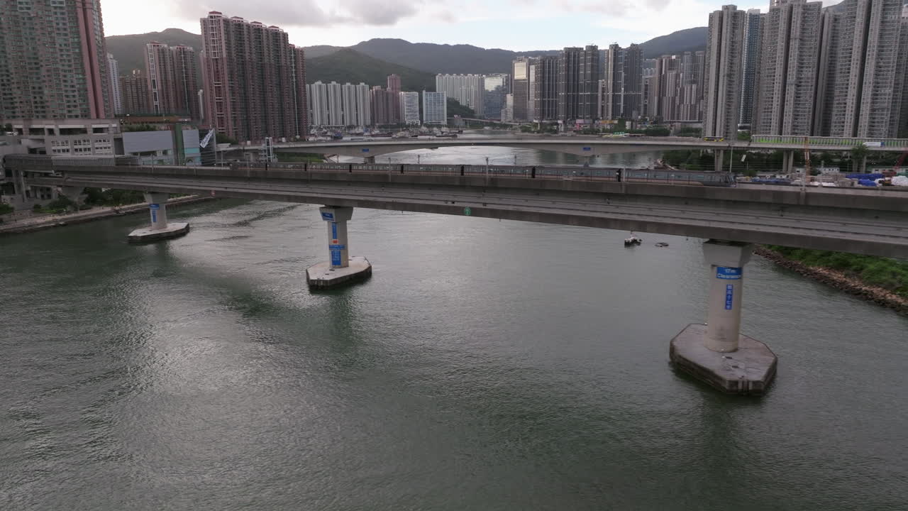toma de seguimiento aéreo después de que el tren cruce un puente sobre el océano en hong kong