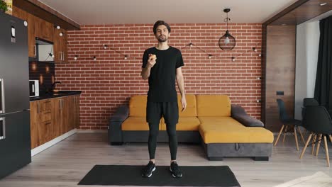 hombre deportivo en forma comiendo manzana para un bocadillo ligero en la sala de estar