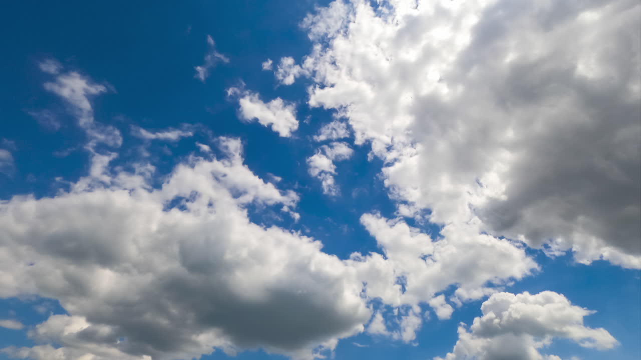 Cloudscape formation in the atmosphere. Amazing timelapse of white fluffy clouds moving softly on the sky and the sun shining above the clouds with beautiful rays.