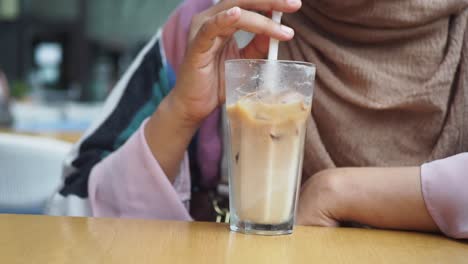 woman drinking iced coffee at a cafe