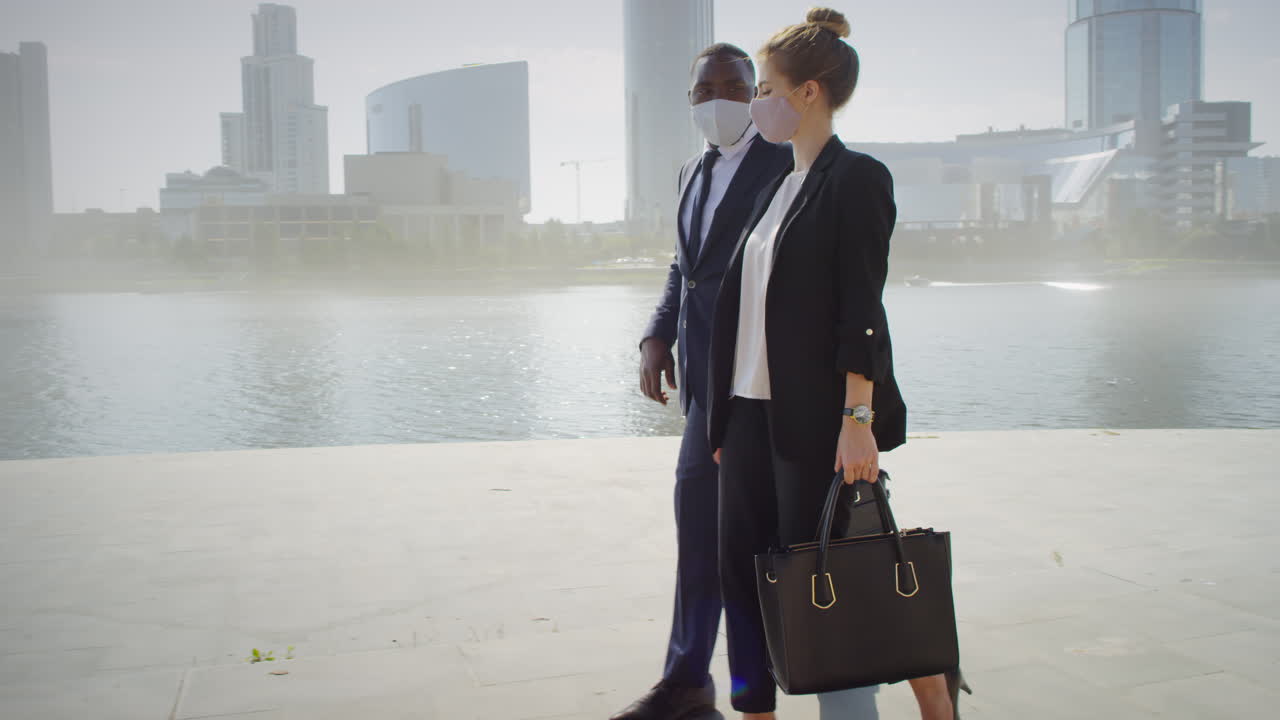 Business Couple Walking Down Sidewalk Near River