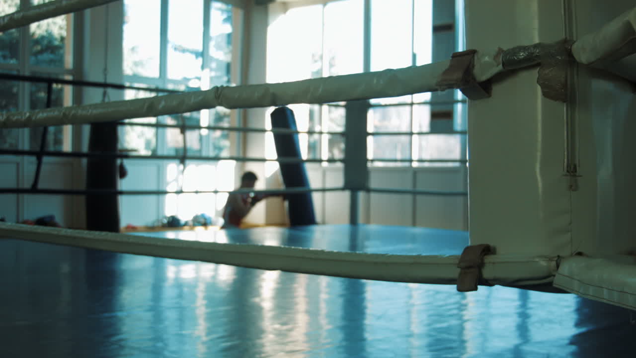 Silhouette Of Young Boxer Training With Punching Bag