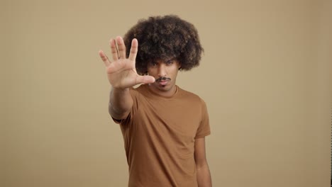 man with afro hair making stop gesture