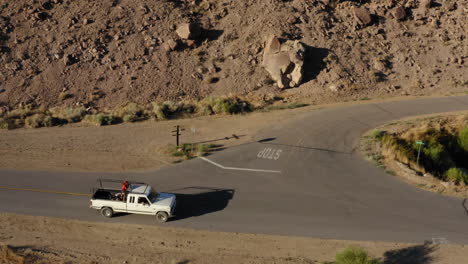 flight over the desert then chasing a car along a road through the bleak landscape