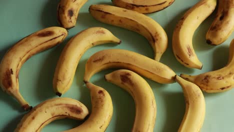 Eine-Makroaufnahme-Reifer-Gelber-Bio-Bananen,-Die-Sich-Vor-Grünem-Hintergrund-Drehen