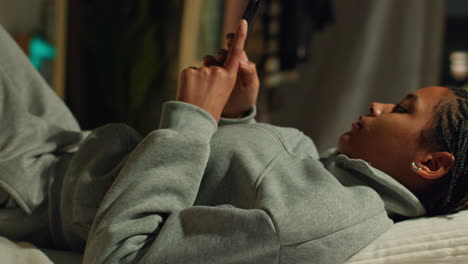 adolescente usando el teléfono en la cama