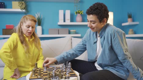 Boy-playing-chess-with-his-mother-at-home.