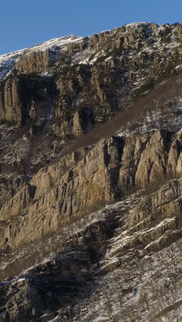 snowy mountain range with rocky cliffs