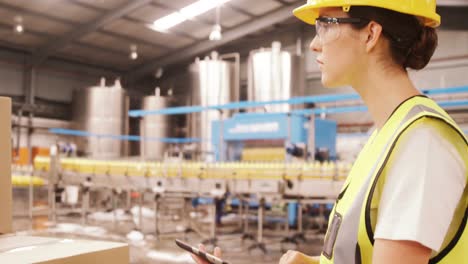 Worker-maintaining-record-on-digital-tablet-while-cardboard-boxes