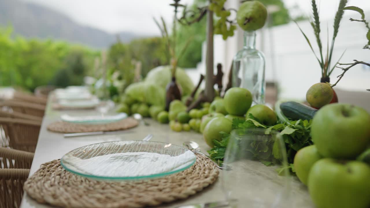 Close up of an artistic dinner table setting using fresh fruit and vegetables in an outdoor setting