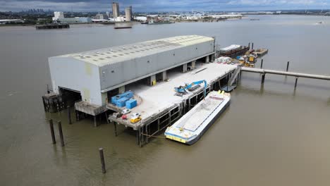 barge unloading at dock on river thames uk essex drone footage