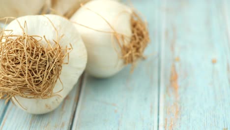 close-up of fresh garlic bulbs on a light blue wooden table