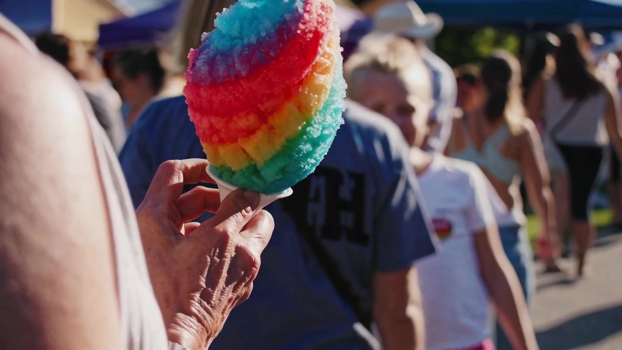 La folla si gode una granita colorata al mercato all'aperto.