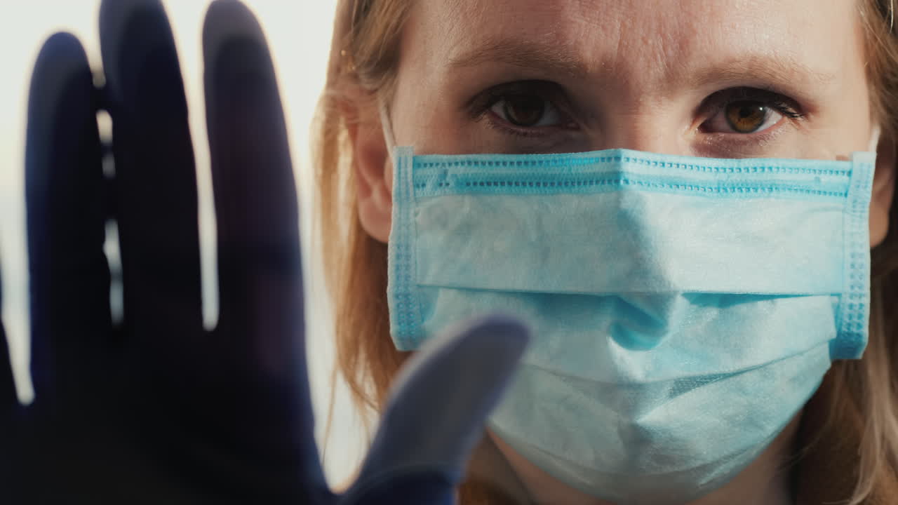 la mujer toca la mano con la otra mano a través del cristal