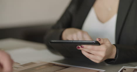 extreme close up of business woman using tablet computer on a meeting 1