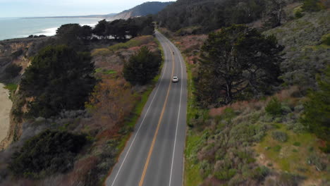 aerial of motorcyclist riding on california coast highway one