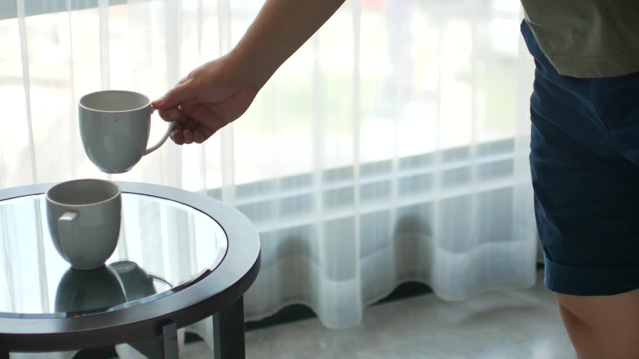 테이블에서 차나 커피 한 잔을 손에 들고