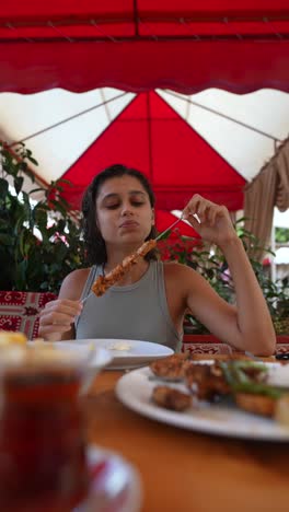 woman enjoying delicious chicken skewers outdoors