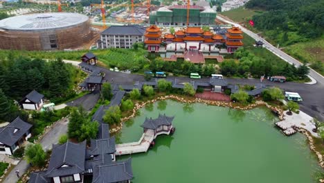 vista aérea del parque huaxiacheng con edificios tradicionales y un lago en weihai, china