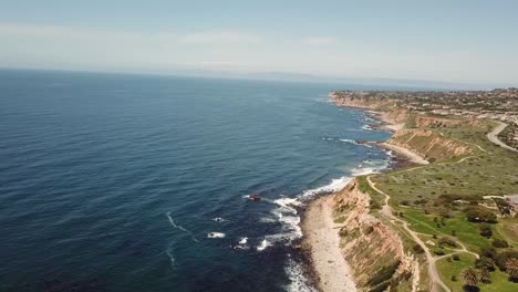 4k drone shot of breathtaking pacific ocean views with cliffs in palos verdes, los angeles, california on a warm, sunny day