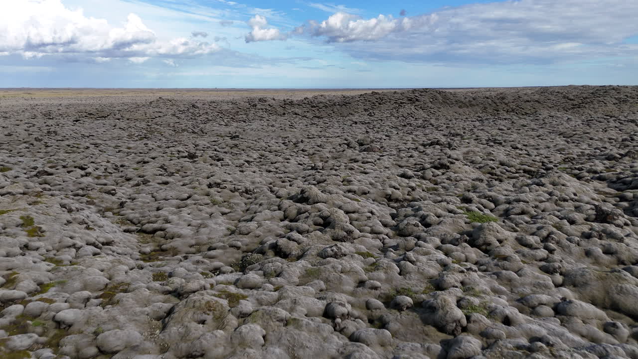 Luminosa veduta aerea del vasto campo di lava ricoperto di muschio islandese sotto nuvole sparse, che mette in mostra trame vulcaniche uniche e la bellezza aspra degli altopiani