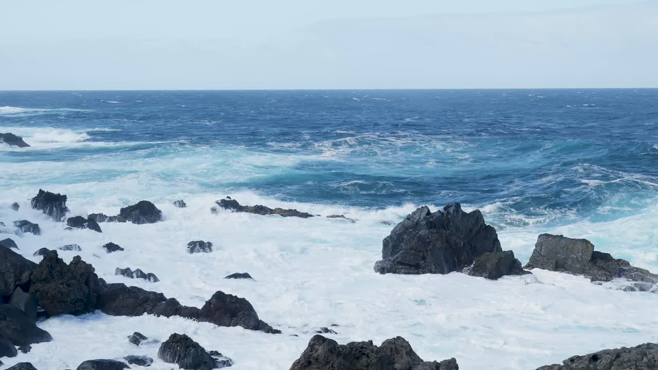 Potenti onde dell'oceano si schiantano contro la costa rocciosa