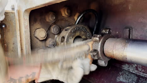 unrecognized worker in gloves uses a wrench turning the nut. machines and equipment for oil production.