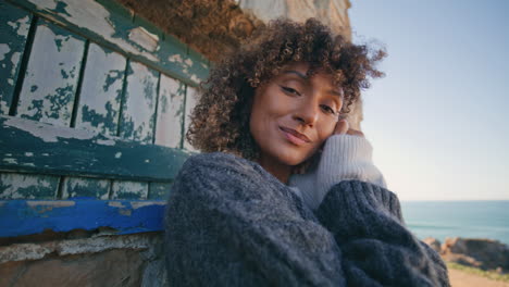 autumn girl touching curls looking camera old door closeup. happy woman posing