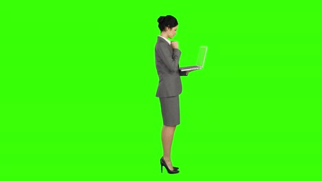 Business-woman-standing-and-using-a-laptop