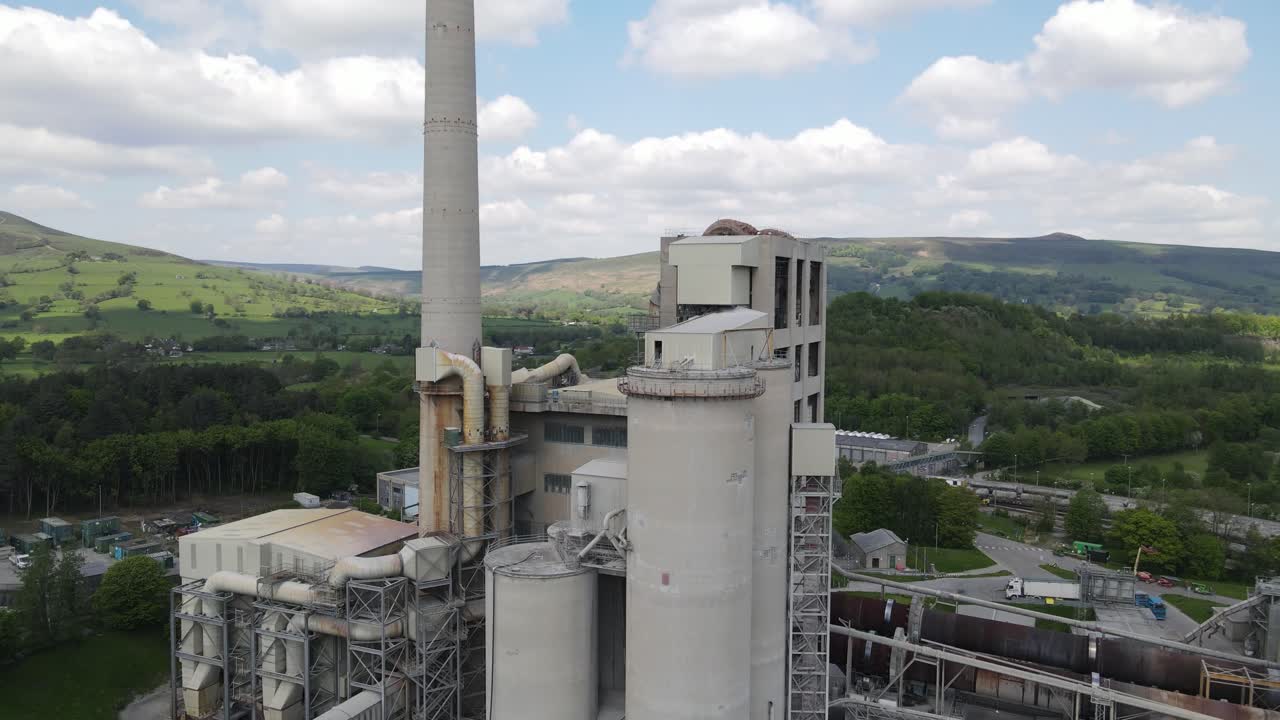 vuelo aéreo de drones alrededor del edificio principal de las fábricas de cemento breedon hope con una vista panorámica de mam tor en castleton