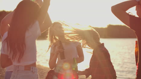 Young-people-celebrate-a-birthday-on-the-beach-party-with-beer-and-good-mood.-This-is-carefree-summer-evening-at-sunset.